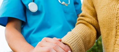 nurse holding elderly woman's hand