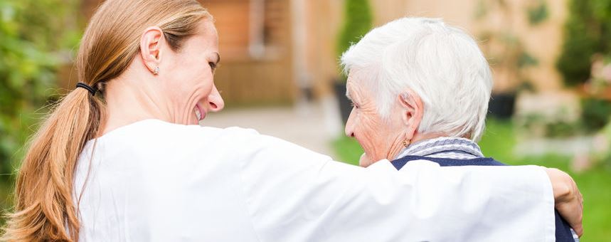 caregiver with her arm around senior woman