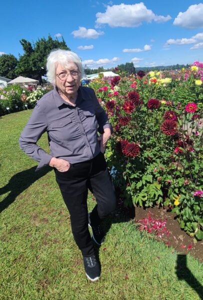 elderly woman next to field of flowers on an outing 